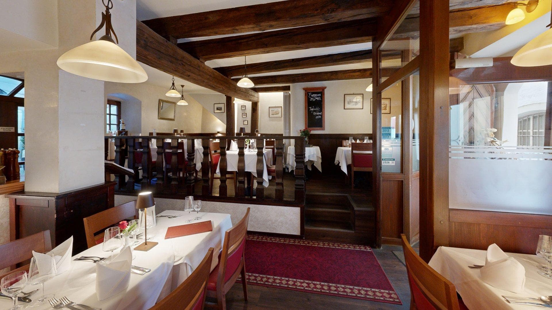 Gastraum mit Treppe und Holzbalken